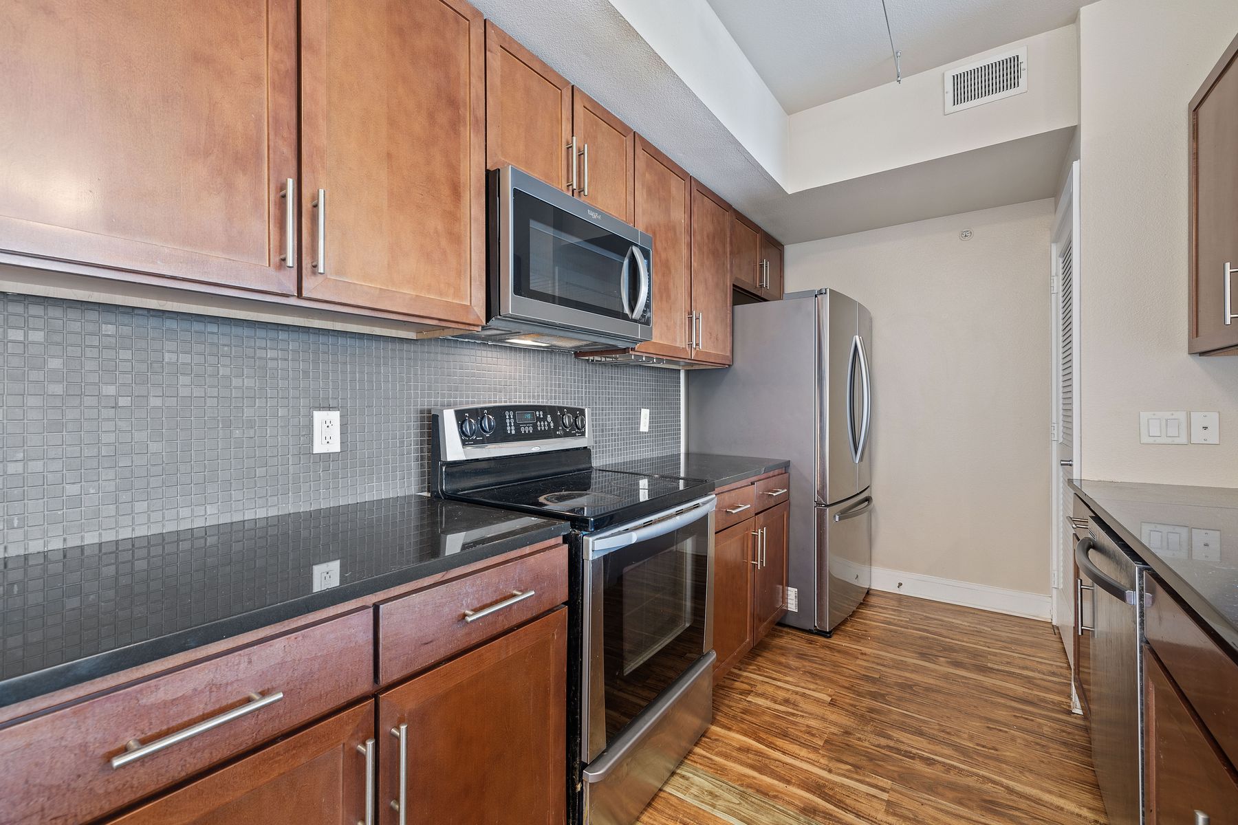 3016 Guadalupe Street, Unit 303 Austin, TX 78705 - Photo 3 of 15 a kitchen with stainless steel appliances granite countertop a refrigerator stove and microwave