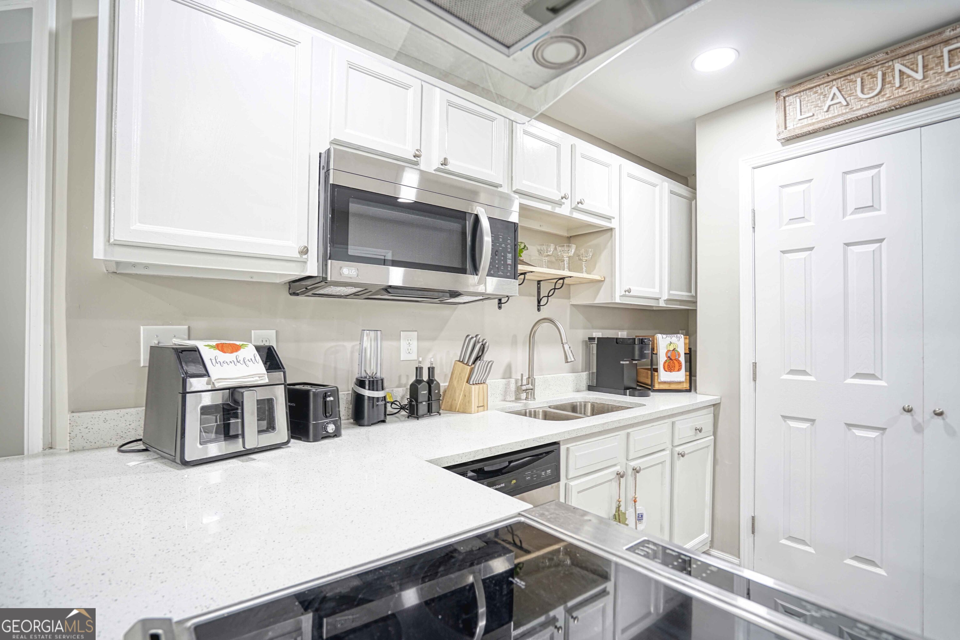 1827 Dunlap Avenue East Point, GA 30344 - Photo 18 of 32 a kitchen with stainless steel appliances a stove microwave and cabinets
