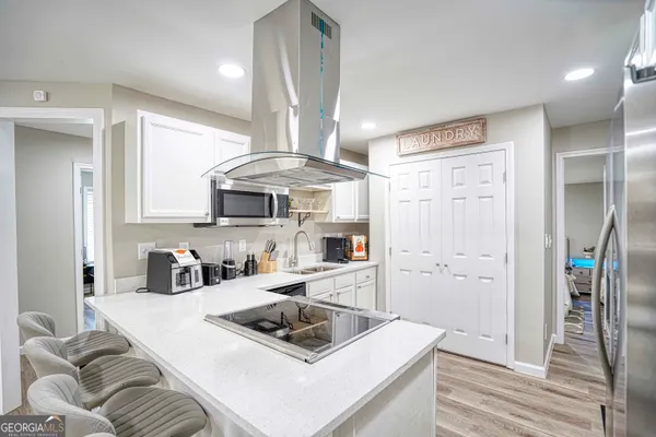 a kitchen with stainless steel appliances a sink a stove a refrigerator and cabinets