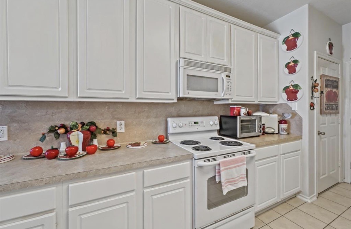 13134 Peppergate Lane Houston, TX 77044 - Photo 10 of 23 a kitchen with white cabinets and white appliances