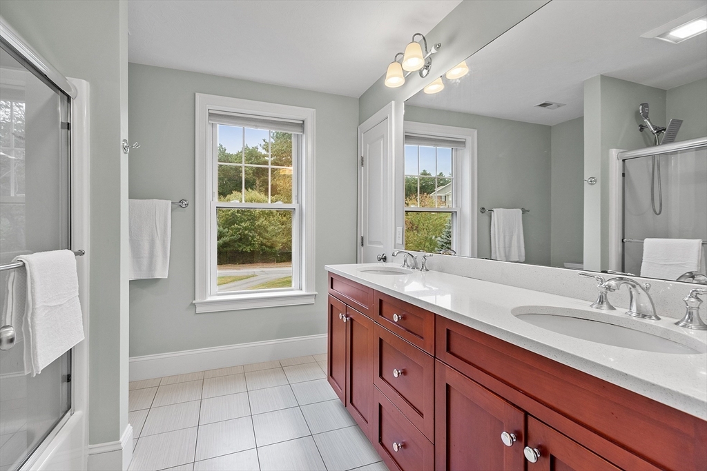 42 Fox Run Road Bolton, MA 01740 - Photo 25 of 42 a bathroom with a granite countertop double vanity sink a mirror and a shower