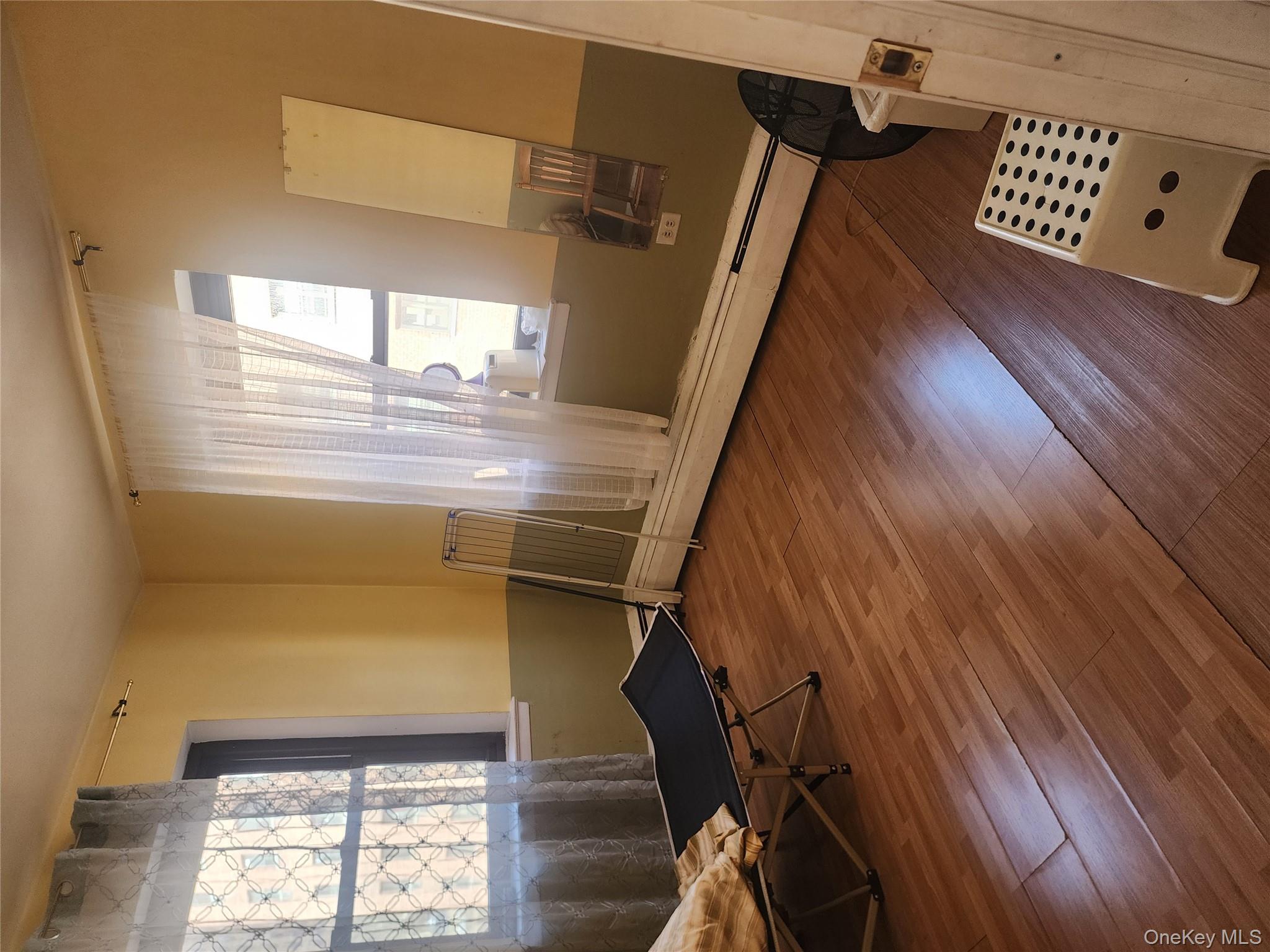 99-11 60th Avenue, Unit 3E Queens, NY 11368 - Photo 12 of 12 a living room with furniture and a window