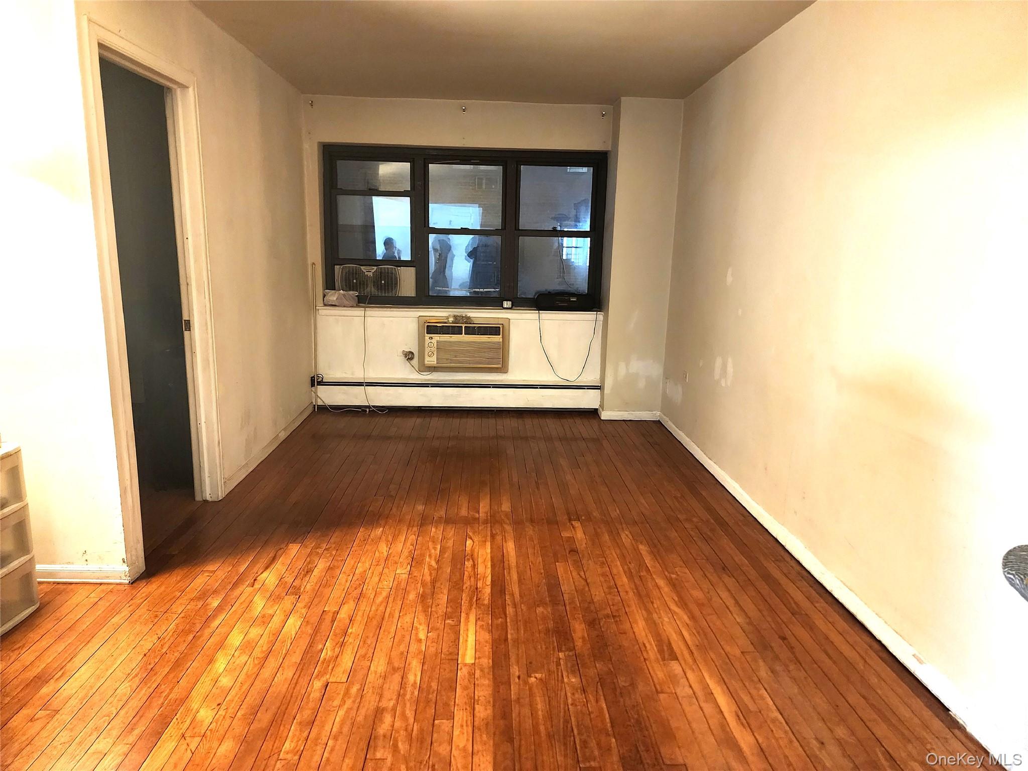 99-11 60th Avenue, Unit 3E Queens, NY 11368 - Photo 8 of 12 a view of a room with wooden floor and a window