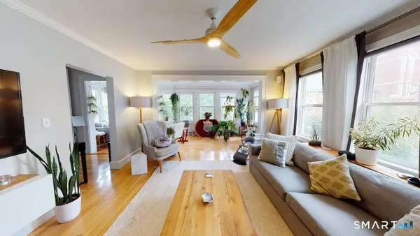 a living room with furniture fireplace and a large window