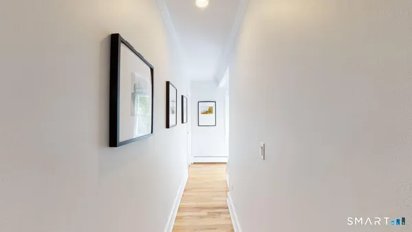 a hallway with wooden floor windows and stairs