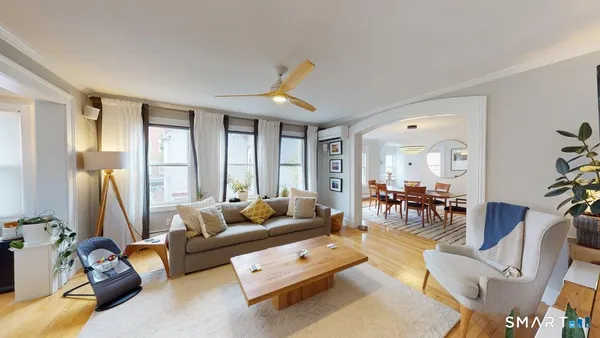 a living room with furniture a flat screen tv and a large window