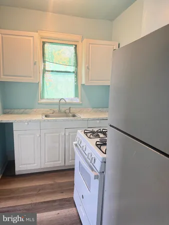 a kitchen with a sink stove top oven and cabinets