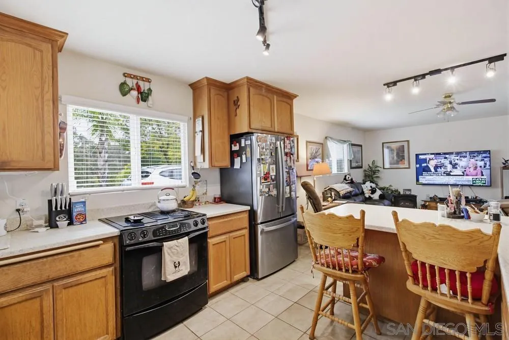 1478 Peutz Valley Road Alpine, CA 91901 - Photo 14 of 63 a kitchen with stainless steel appliances a stove a refrigerator a sink dishwasher a dining table and chairs with wooden floor