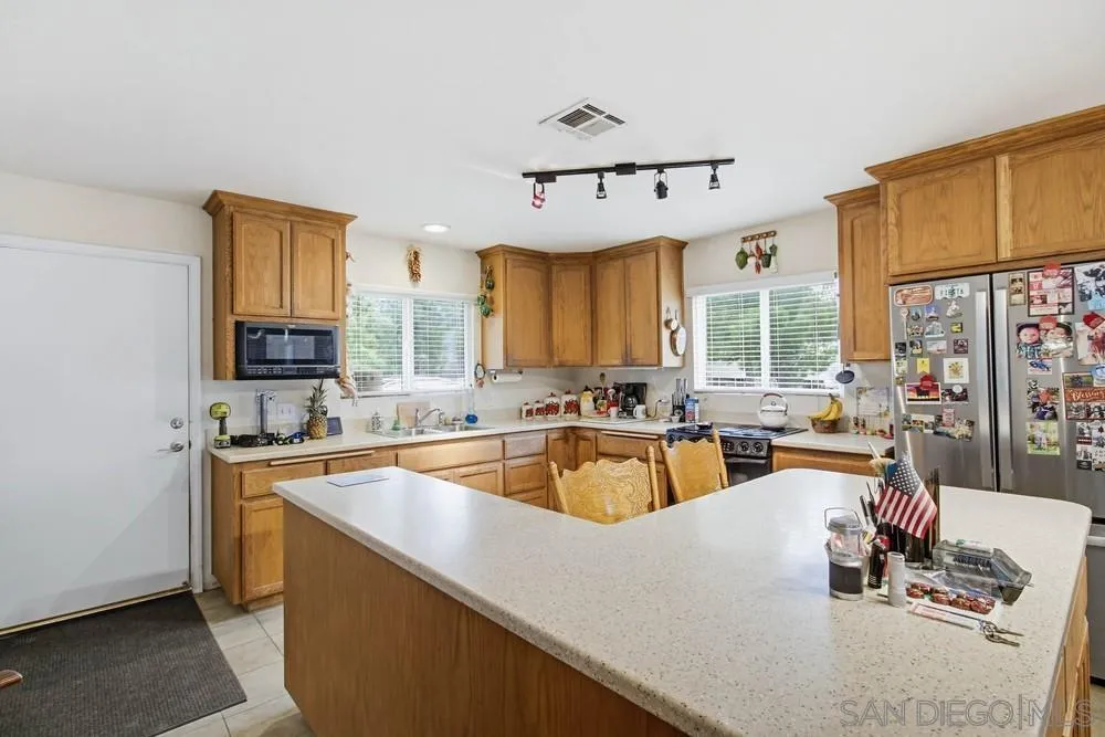 1478 Peutz Valley Road Alpine, CA 91901 - Photo 9 of 63 a kitchen with stainless steel appliances a sink a stove and a refrigerator