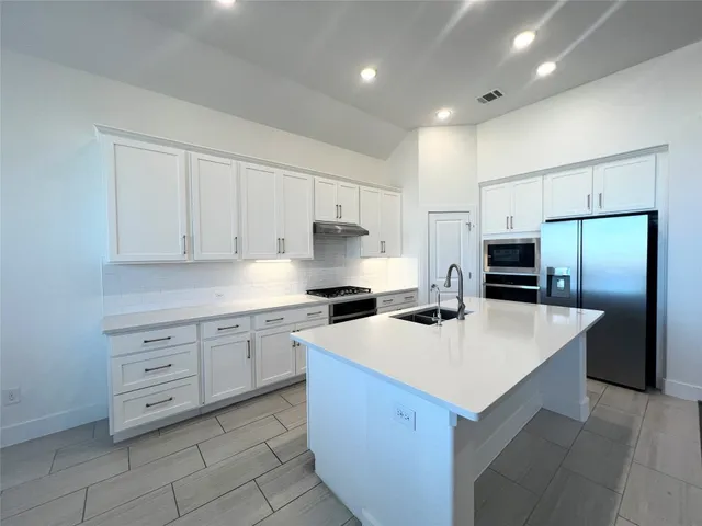 a view of kitchen with kitchen island wooden floor center island and stainless steel appliances