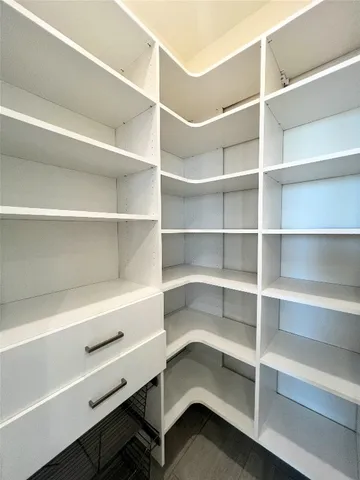 a view of walk in closet with empty racks