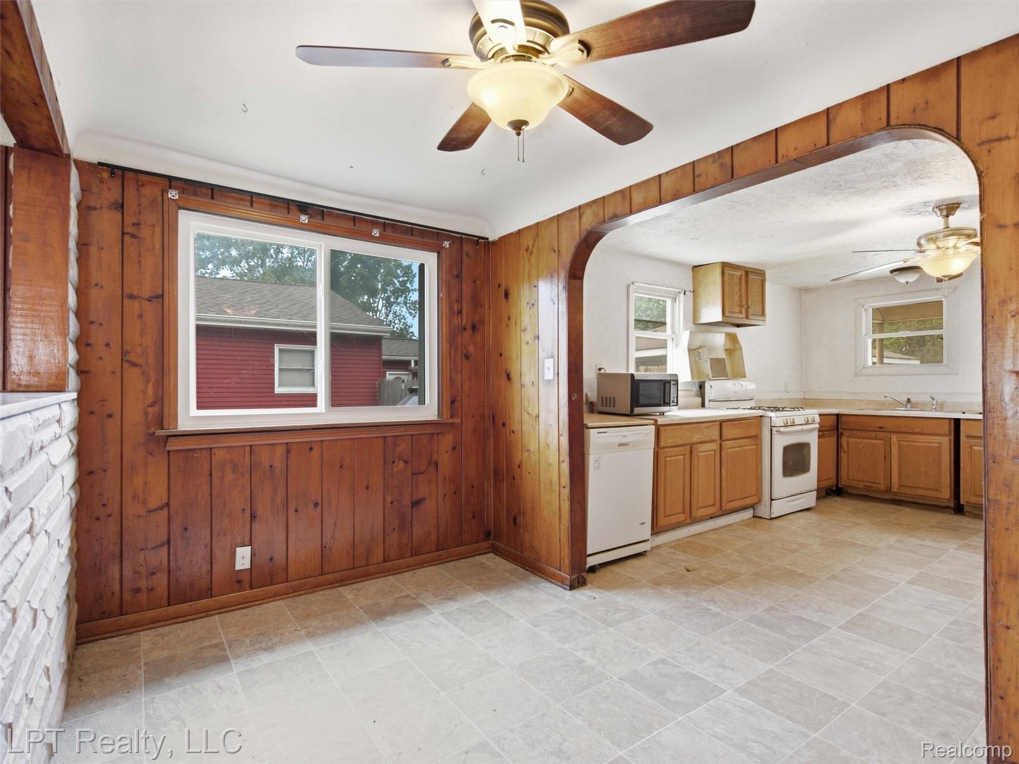 3385 North Genesee Road Flint, MI 48506 - Photo 11 of 24 Kitchen with wood-finish cabinetry, white appliances, and a ceiling fan
