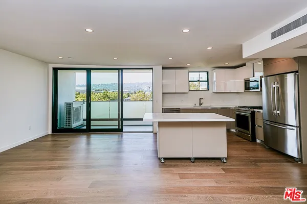 a view of kitchen with granite countertop refrigerator stove sink and cabinets