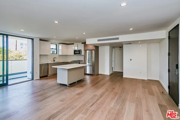 a large kitchen with stainless steel appliances granite countertop a lot of counter space and wooden floor