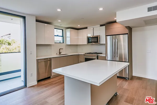 a kitchen with stainless steel appliances a refrigerator sink and microwave