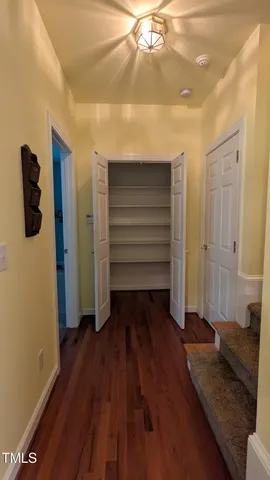 a view of a hallway with wooden floor and closet