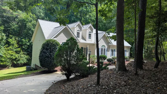 a aerial view of a house with a yard and large trees