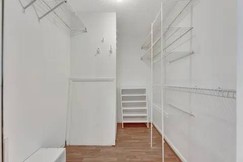 a view of an empty room with wooden floor