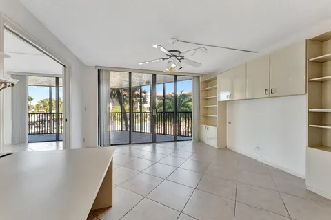 a view of a big room with windows and chandelier fan