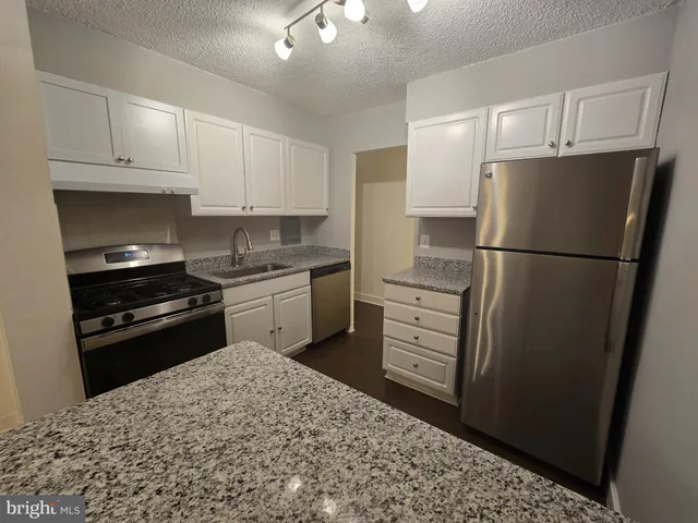 a kitchen with a refrigerator stove and white cabinets