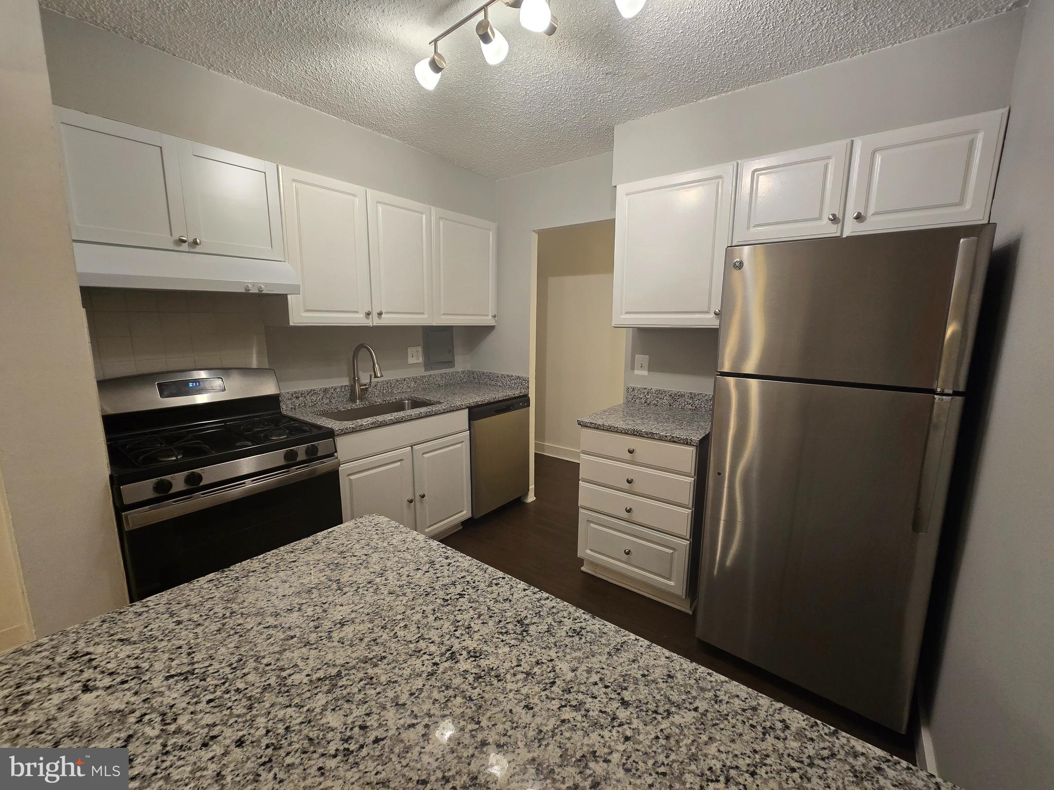 5901 Tamar Drive, Unit 10 S10 Columbia, MD 21045 - Photo 1 of 27 a kitchen with a refrigerator stove and white cabinets