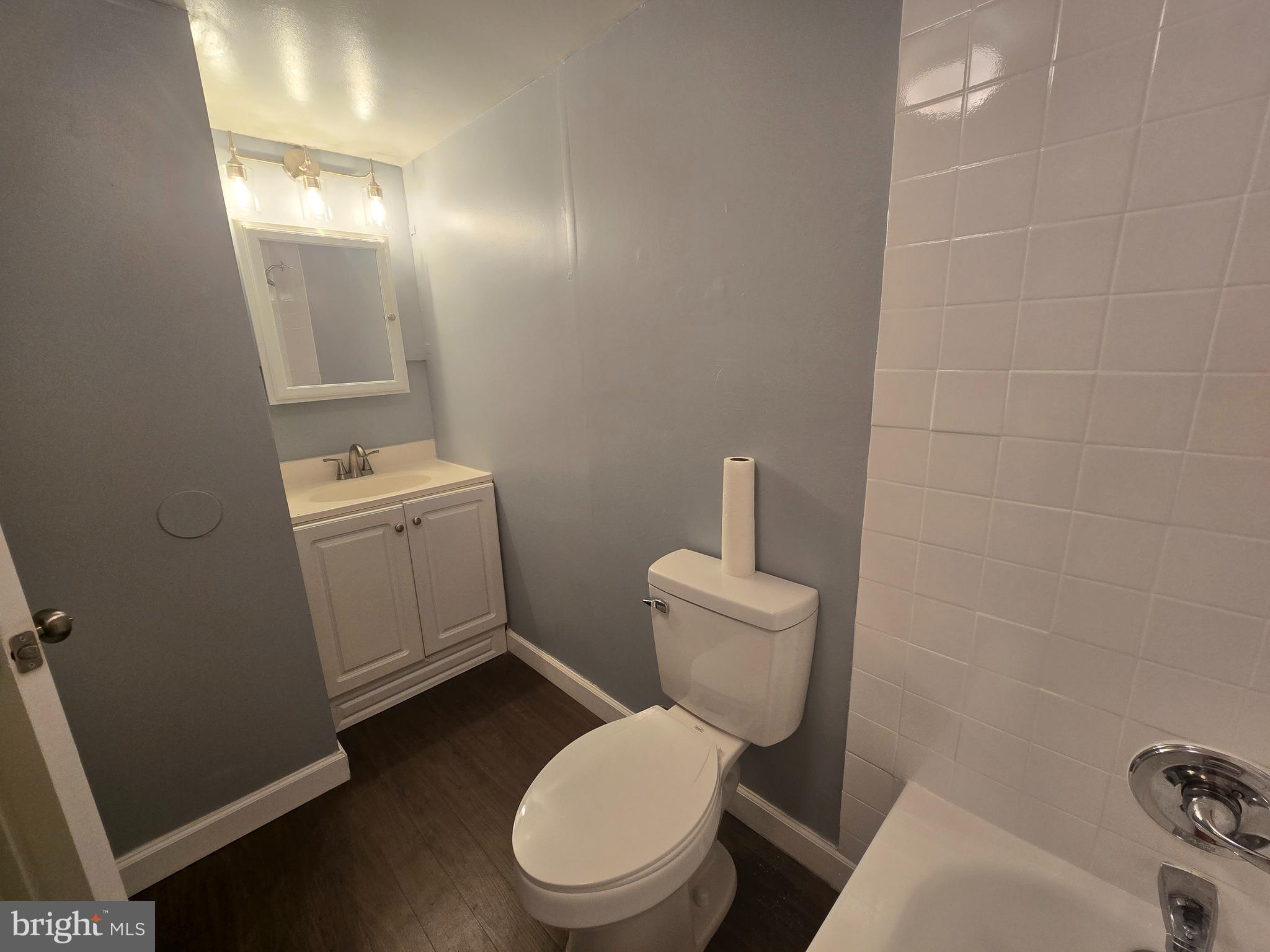 5901 Tamar Drive, Unit 10 S10 Columbia, MD 21045 - Photo 19 of 27 a white toilet sitting next to a bathroom sink and vanity