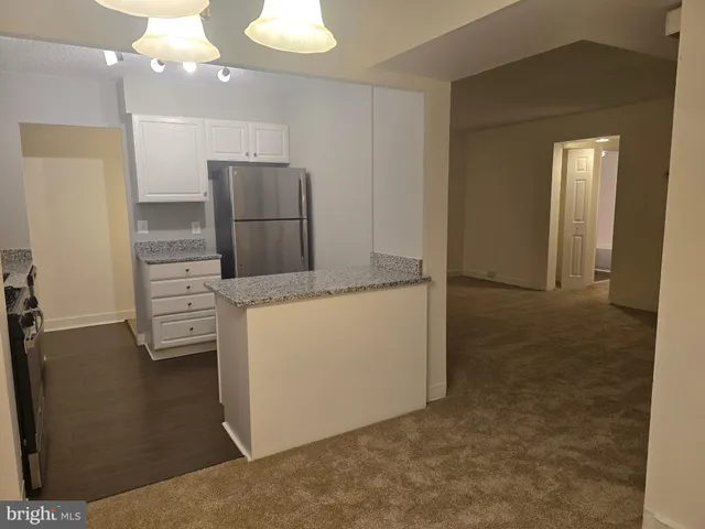 a kitchen with kitchen island cabinets and refrigerator