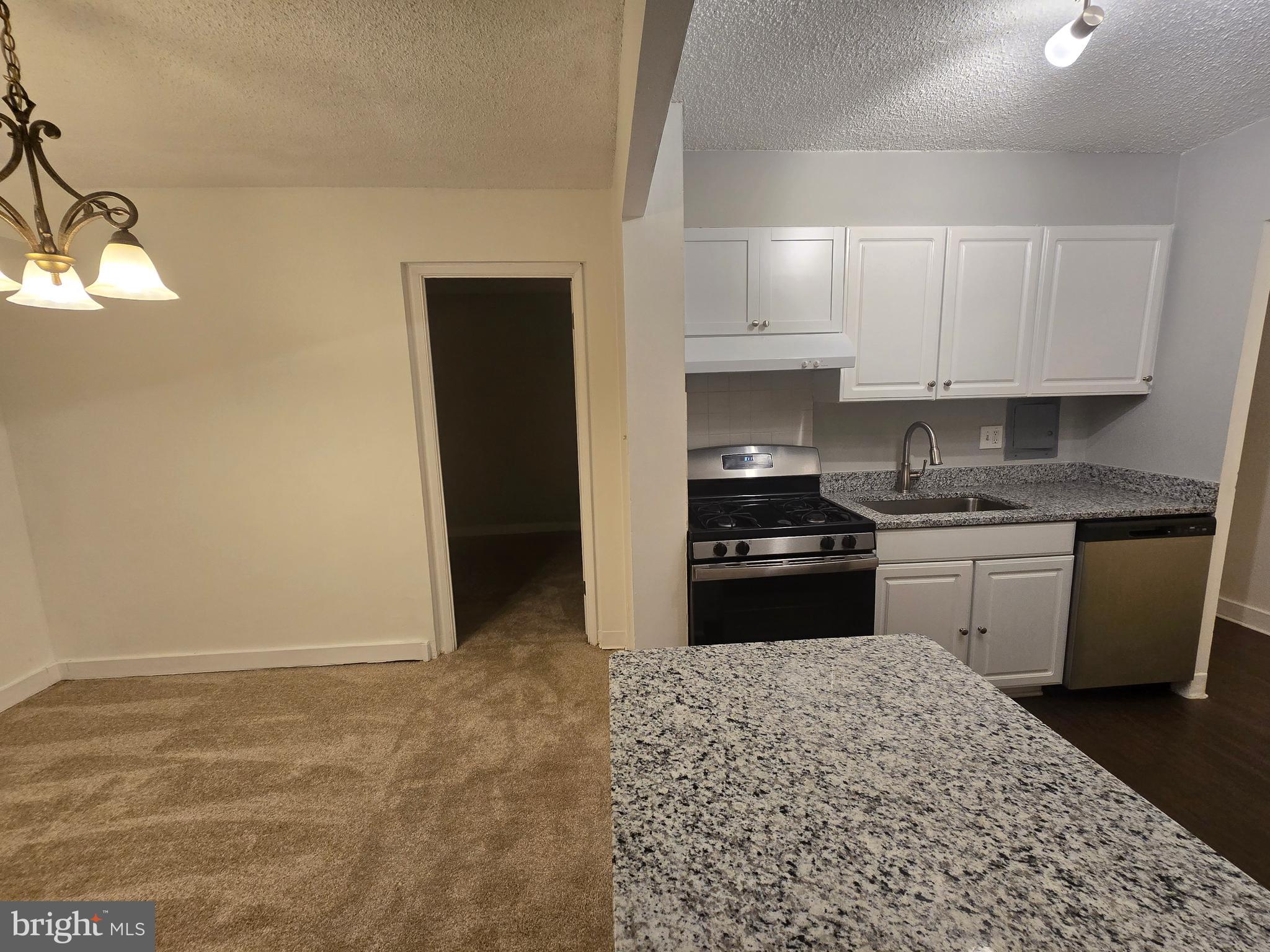 5901 Tamar Drive, Unit 10 S10 Columbia, MD 21045 - Photo 6 of 27 a kitchen with granite countertop white cabinets and refrigerator