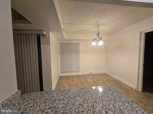 a view of a hallway with a chandelier fan