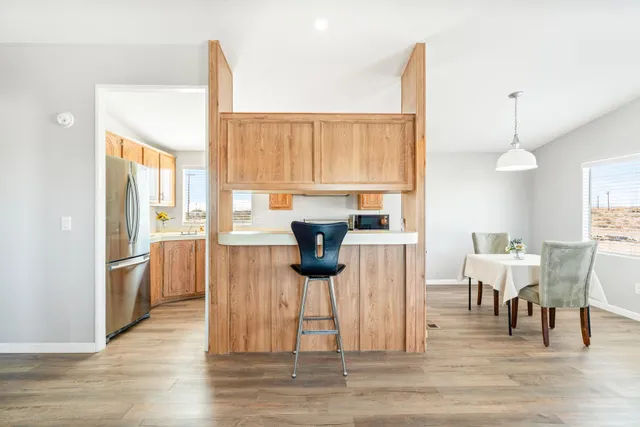 a view of a dining room and livingroom with furniture wooden floor a chandelier