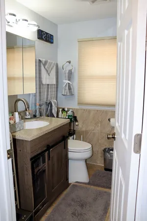 a bathroom with a double vanity sink toilet and a mirror