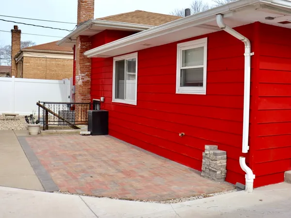 a backyard of a house with table and chairs