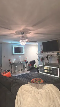 a living room with furniture and a chandelier