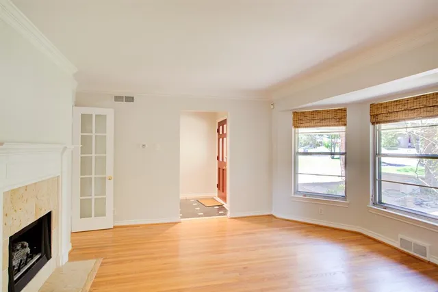 an empty room with windows and fireplace