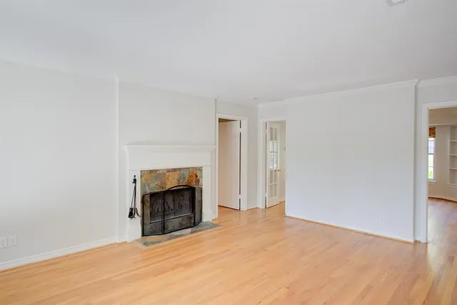 a view of an empty room with a fireplace and a window