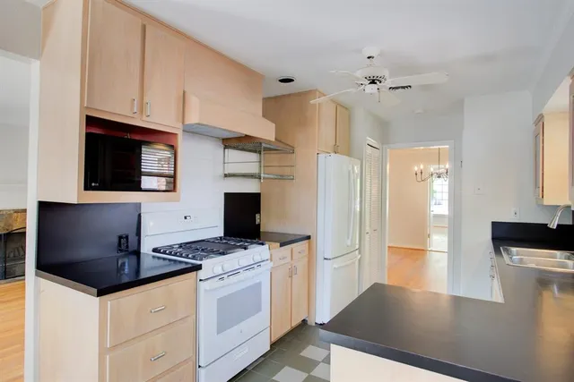 a kitchen with stainless steel appliances a stove a refrigerator a sink a counter space and cabinets