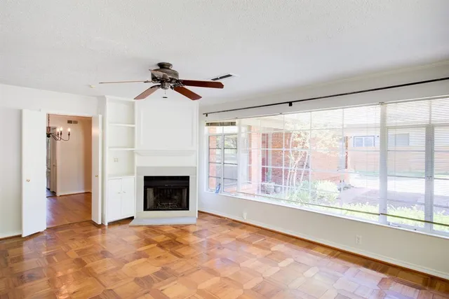 a view of an empty room with a fireplace and a window
