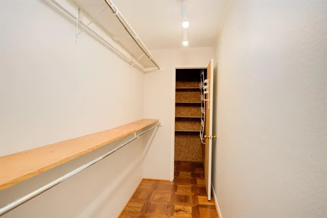 a view of walk in closet with empty racks