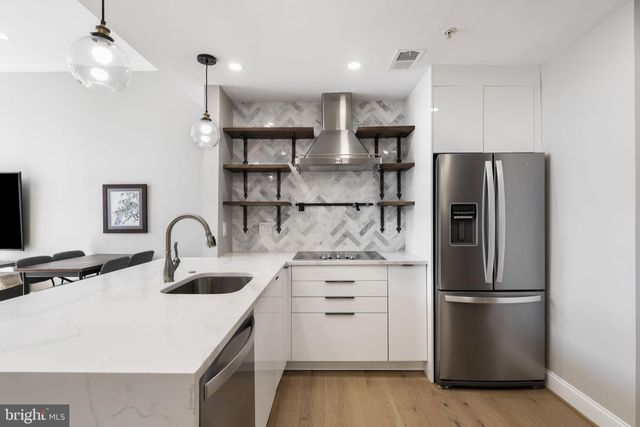 a kitchen with kitchen island stainless steel appliances a refrigerator and a sink