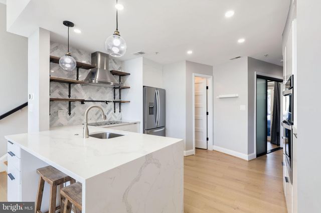 a kitchen with kitchen island a sink and refrigerator