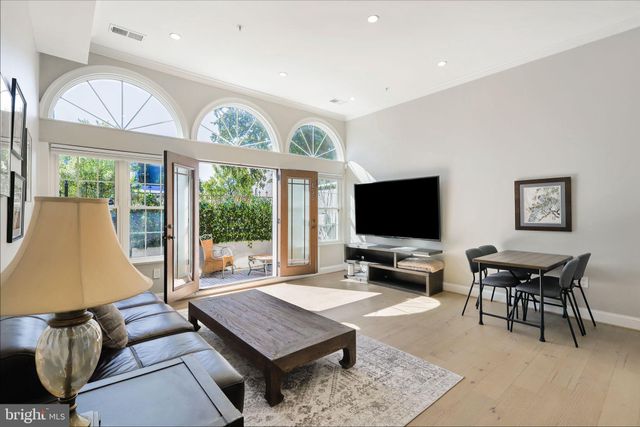 a living room with furniture a flat screen tv and a large window