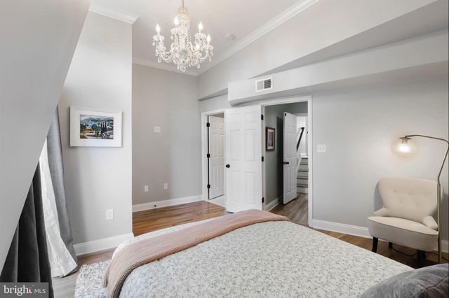 a bedroom with a large bed and a chandelier