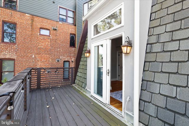 a view of a balcony with wooden floor and floor to ceiling window