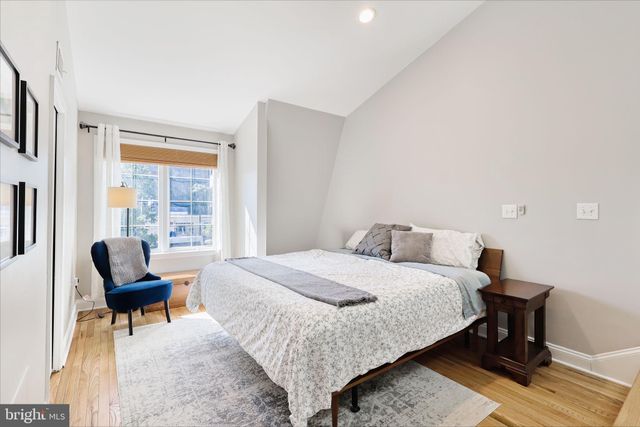 a bedroom with a bed chairs and a window