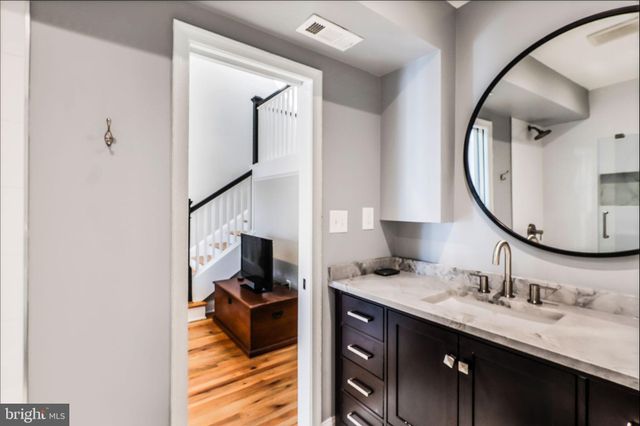 a en suite bathroom with a granite countertop sink and a mirror
