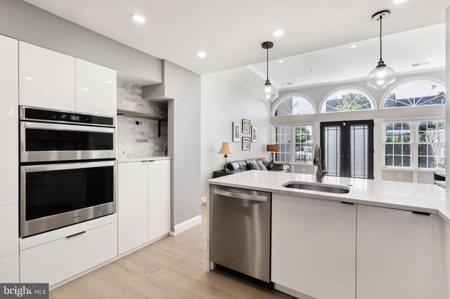 a kitchen with stainless steel appliances granite countertop a sink and a refrigerator