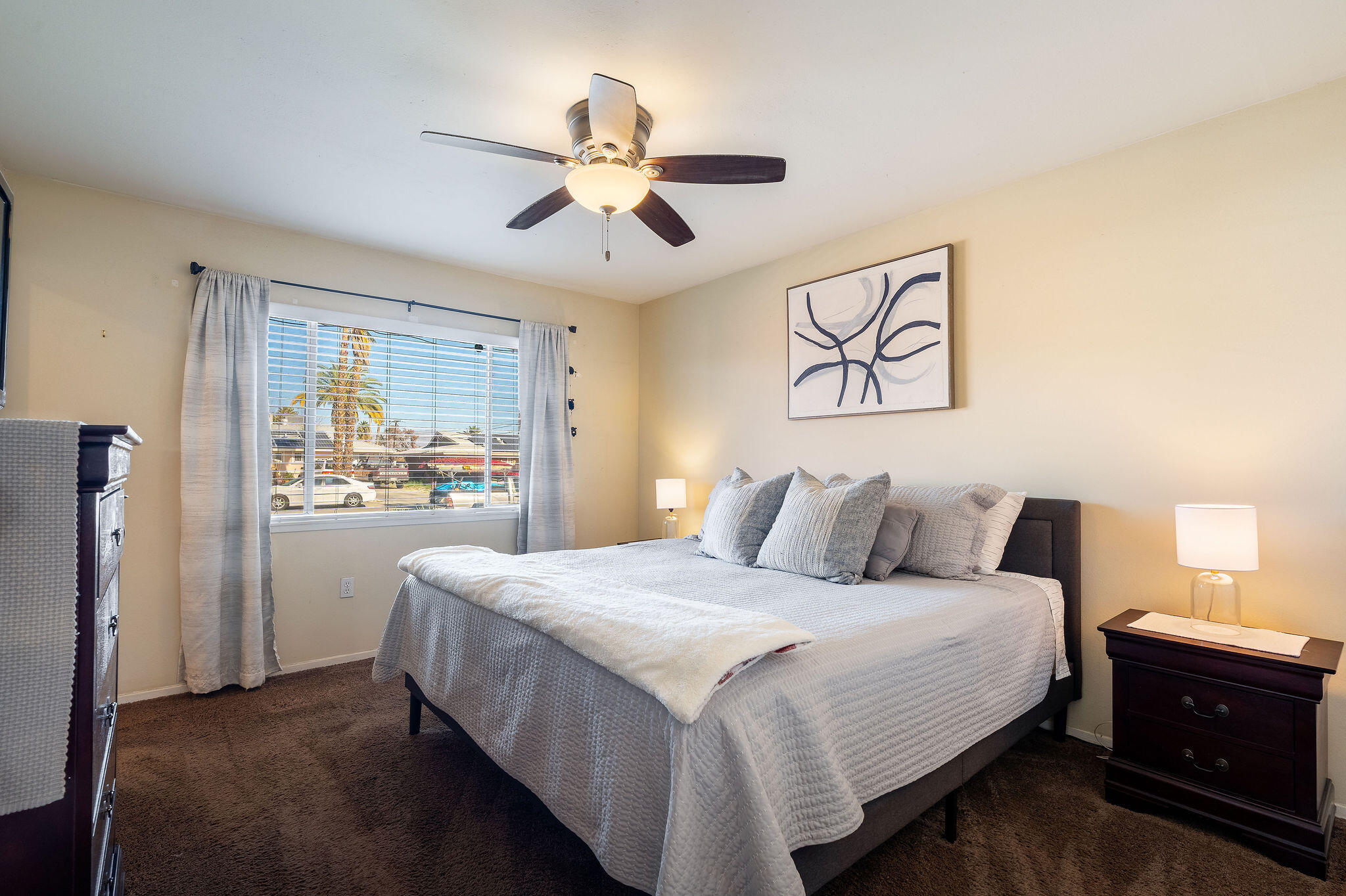 42735 Kansas Street Palm Desert, CA 92211 - Photo 29 of 48 a bedroom with a large bed and a chandelier