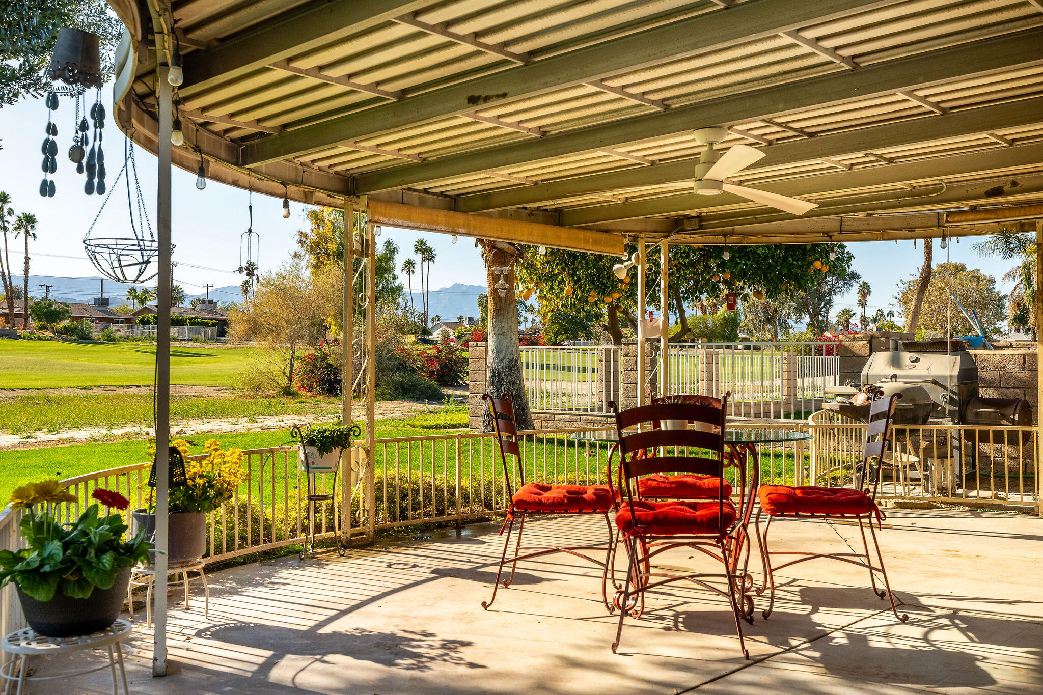 42735 Kansas Street Palm Desert, CA 92211 - Photo 36 of 48 a view of a patio with a table and chairs next to a yard
