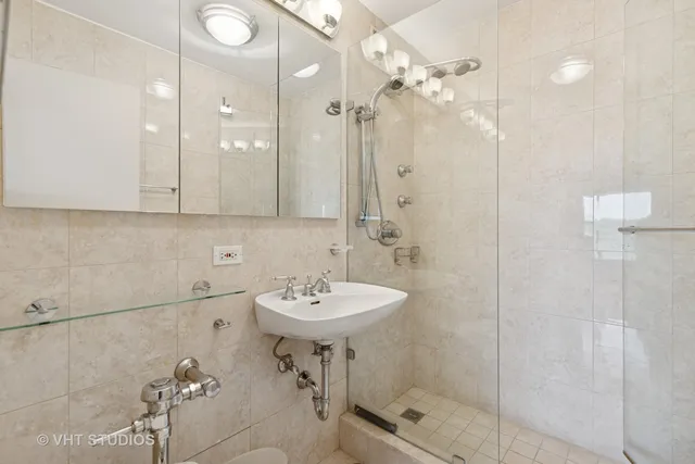 a bathroom with a sink shower and a mirror