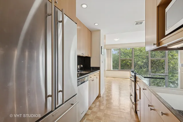 a view of a kitchen with a sink and dishwasher with wooden floor